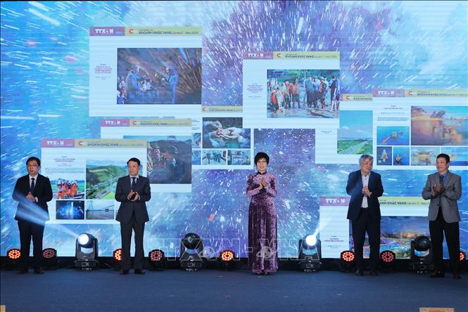Tổng giám đốc TTXVN Vũ Việt Trang cùng các đại biểu thực hiện nghi lễ khai trương trưng bày 22 tác phẩm xuất sắc đạt Giải ảnh báo chí Khoảnh khắc Vàng lần thứ 7. Ảnh: Hoàng Hiếu - TTXVN