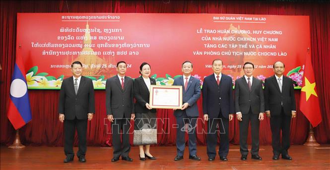 Đại sứ Việt Nam tại Lào Nguyễn Minh Tâm trao tặng Huân chương Độc lập hạng Nhất cho tập thể Văn phòng Chủ tịch nước Lào. Ảnh: Xuân Tú - PV TTXVN tại Lào