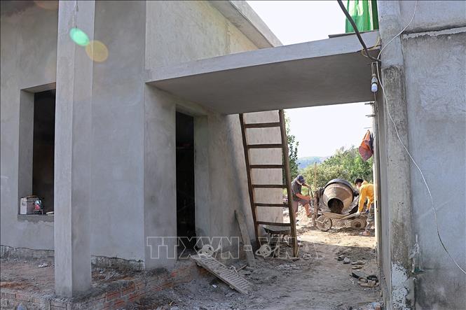 Thợ xây dựng và người thân giúp hộ gia đình bà Nguyễn Thị Thu, khu Ban Rừng, thị trấn Mãn Đức, huyện Tân Lạc xây dựng nhà mới. Ảnh: Thanh Hải - TTXVN  
