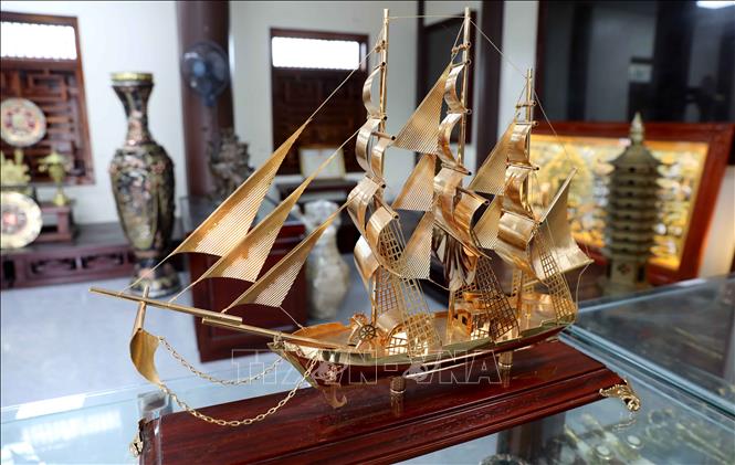 Tác phẩm “Thuận buồm xuôi gió” của làng nghề chạm bạc Đồng Xâm hút khách dịp Tết. Ảnh: Thế Duyệt – TTXVN
