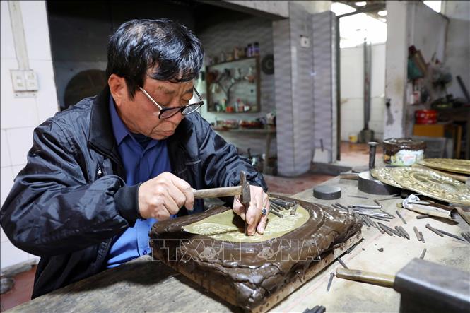 Nghệ nhân Đinh Quang Thắng (66 tuổi, thôn Nam Hòa, xã Hồng Thái) khắc chạm thủ công bằng kỹ thuật tinh xảo. Ảnh: Thế Duyệt – TTXVN