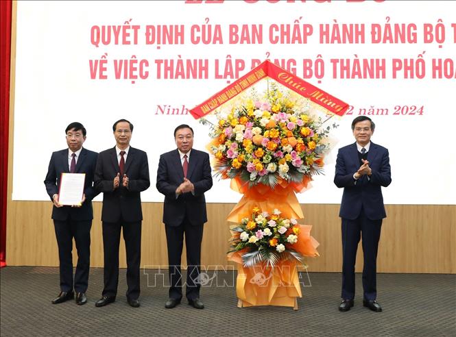 Đồng chí Đoàn Minh Huấn, Ủy viên Trung ương Đảng, Bí thư Tỉnh ủy Ninh Bình trao Quyết định và chúc mừng Đảng bộ thành phố Hoa Lư. Ảnh: Đức Phương - TTXVN
