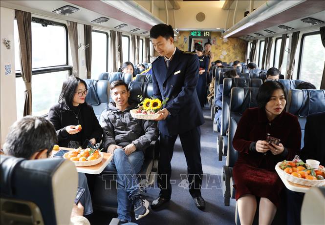 Nhân viên đường sắt phục vụ bánh đặc sản của Hà Nội trên tàu du lịch Hà Nội - Thái Nguyên. Ảnh: Hoàng Nguyên - TTXVN