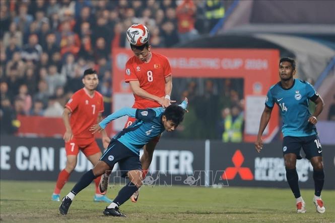 Pha đánh đầu vào lưới đối phương của tiền vệ Châu Ngọc Quang (số 8) nhưng bàn thắng không được công nhận do cầu thủ này đã phạm lỗi với hậu vệ Singapore. Ảnh: Minh Quyết - TTXVN