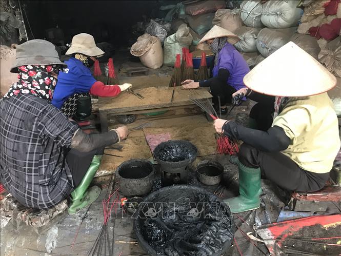Các công nhân quét nhựa trám vào que hương tại làng hương Dưỡng Thái Bắc, huyện Kim Thành, tỉnh Hải Dương. Ảnh: Tiến Vĩnh – TTXVN