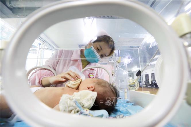 Nhân viên y tế chăm sóc em bé sơ sinh tại bệnh viện ở Khu tự trị dân tộc Choang Quảng Tây, Trung Quốc. Ảnh: THX/TTXVN