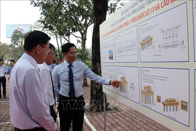 Các đại biểu nghe giới thiệu về giải pháp thi công nâng tĩnh không cầu Bình Phước 1 và Bình Triệu 1. Ảnh: Tiến Lực - TTXVN
