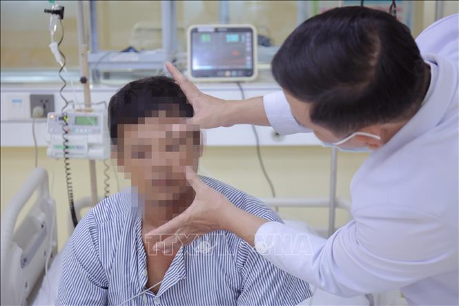 Bác sỹ kiểm tra vết đốt trên mặt bệnh nhân. Ảnh: TTXVN phát