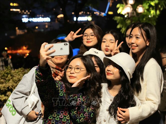 Từ 21h, rất đông người dân đã tập trung quanh khu vực hồ Hoàn Kiếm để chờ xem màn trình diễn ánh sáng bằng drone và bắn pháo hoa. Ảnh: Hoàng Hiếu - TTXVN 