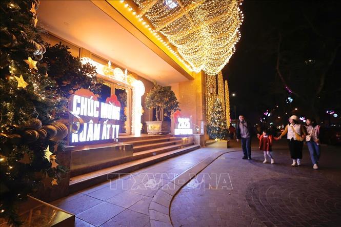 Một gia đình tại không gian Phố đi bộ quanh hồ Hoàn Kiếm, chờ đón khoảnh khắc chuyển giao sang Năm mới 2025. Ảnh: Minh Quyết - TTXVN