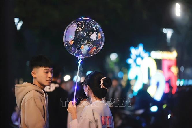 Đôi bạn trẻ cùng chờ đợi khoảnh khắc chuyển giao sang Năm mới 2025. Ảnh: Minh Quyết - TTXVN