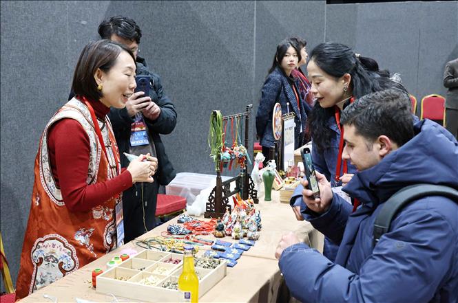 Nhiều người nước ngoài tham gia trải nghiệm tại các gian hàng thủ công mỹ nghệ truyền thống của Trung Quốc trong thời điểm chuyển giao năm mới. Ảnh: Công Tuyên-PV TTXVN tại Trung Quốc