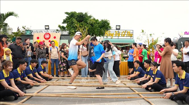 Du khách trãi nghiệm trò chơi dân gian nhảy sạp trên “nóc nhà” Nam Bộ. Ảnh: Minh Phú – TTXVN