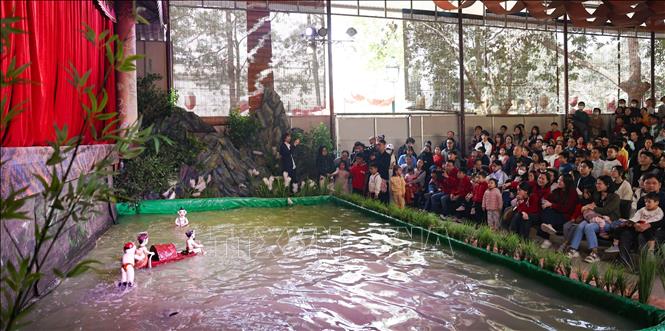 Tourists enjoy a water puppet show at the Thang Long Imperial Citadel World Heritage Site on the first day of New Year 2025. VNA Photo: Thanh Tùng