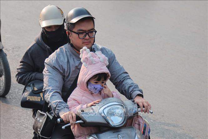 Người dân ra đường nên đeo khẩu trang để phòng chống các bệnh về hô hấp, đặc biệt là người già và trẻ nhỏ. Ảnh: Hoàng Hiếu - TTXVN