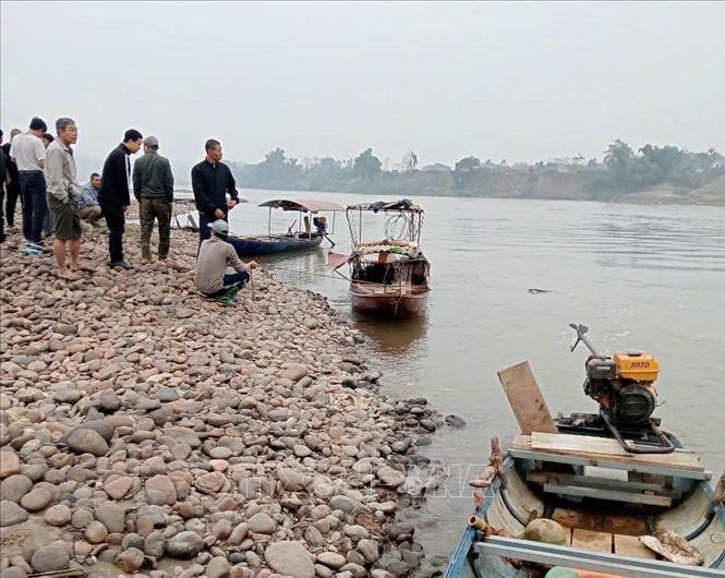 Lực lượng chức năng tổ chức tìm kiếm thi thể hai nạn nhân. Ảnh: TTXVN phát