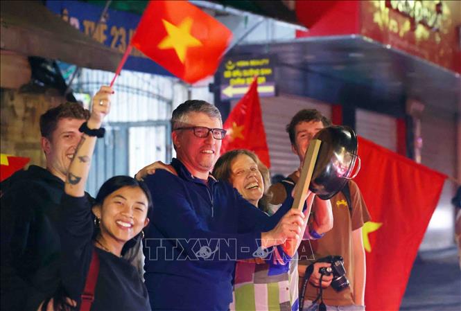 Du khách quốc tế cũng hoà chung niềm vui chiến thắng với người dân Thủ đô. Ảnh: Phạm Kiên - TTXVN