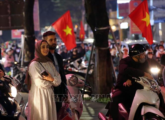 Du khách quốc tế ra đường chung vui với chiến thắng đội tuyển Việt Nam tại thành phố Đà Nẵng. Ảnh: Trần Lê Lâm – TTXVN 