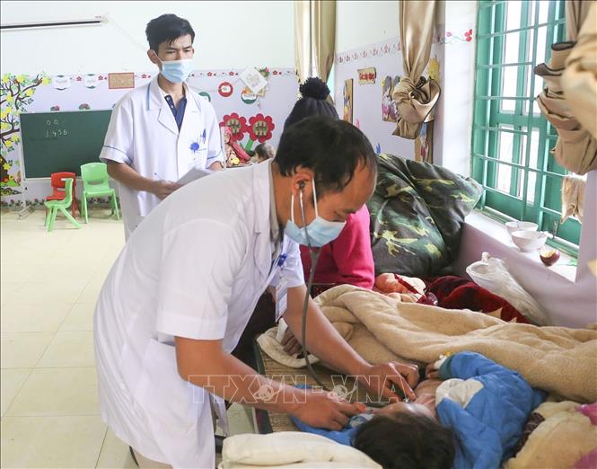 Cán bộ y tế xã Pú Xi, huyện Tuần Giáo khám và điều trị cho các bệnh nhân. Ảnh: TTXVN phát