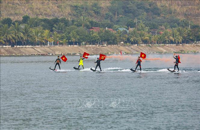 Màn biểu diễn lướt ván phản lực mang theo cờ Đảng, cờ Tổ quốc trên lòng hồ thủy điện. Ảnh: Xuân Tư - TTXVN
