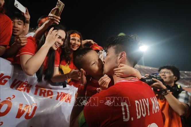 Duy Mạnh vui mừng ôm hôn cậu con trai được mẹ đưa đến sân xem bố thi đấu. Ảnh: Minh Quyết – PV TTXVN từ Thái Lan