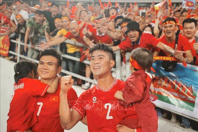 Vietnamese players Xuan Manh and Duy Manh celebrate the national team's victory with their sons. VNA Photo