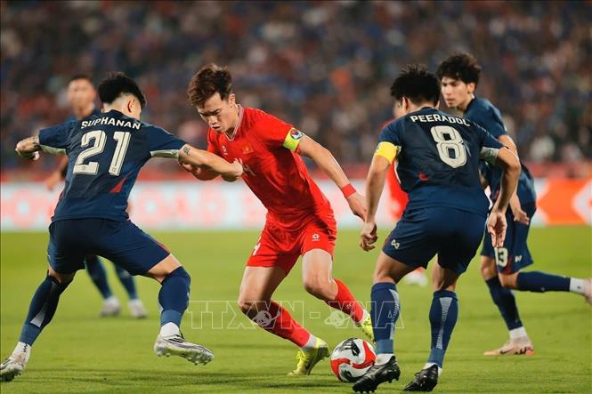 Player Hoang Duc struggles for the ball while being surrounded by Thai players. VNA Photo
