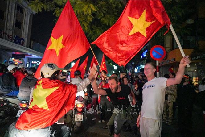 Du khách nước ngoài hoà chung không khí chiến thắng với người hâm mộ Việt Nam. Ảnh: Khánh Hoà - TTXVN
