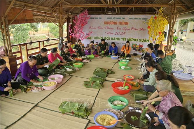 Cán bộ, chiến sĩ Bộ đội Biên phòng Kiên Giang và Hội LHPN gói bánh tét tặng cho người dân. Ảnh: Văn Sĩ - TTXVN