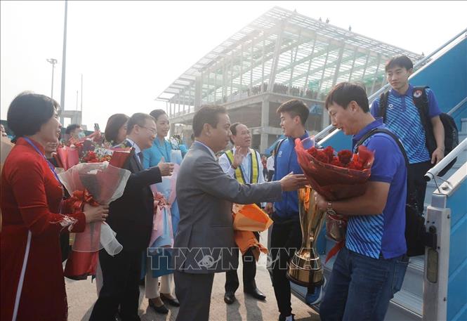 Thứ trưởng Bộ Văn hóa, Thể thao và Du lịch Hoàng Đạo Cương và Phó Cục trưởng Cục TDTT Lê Thị Hoàng Yến đón, tặng hoa chúc mừng HLV Kim Sang-sik và đội tuyển tại chân cầu thang máy bay. Ảnh: Minh Quyết - TTXVN