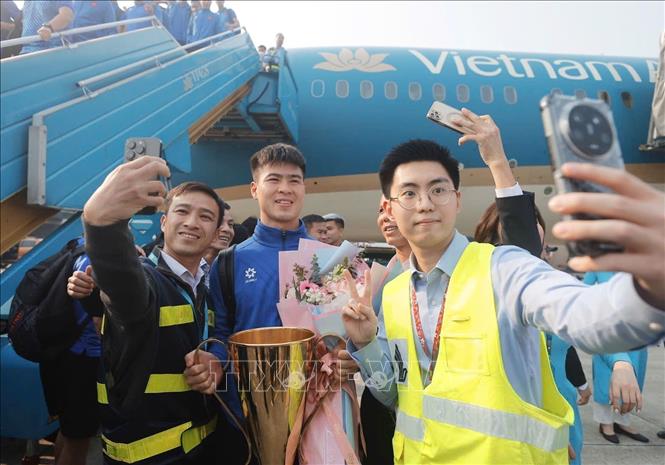 Nhân viên hàng không chụp ảnh selfie cùng Duy Mạnh và cúp vô địch. Ảnh: Minh Quyết - TTXVN