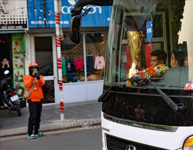 Người hâm mộ chào đón đội tuyển bóng đá Việt Nam cùng chiếc cúp vô địch ASEAN Cup 2024 dọc bên đường Âu Cơ. Ảnh: Thanh Tùng - TTXVN