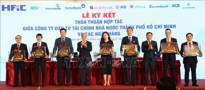 Lãnh đạo HFIC tặng quà lưu niệm cho các ngân hàng tham gia lễ ký kết thỏa thuận hợp tác. Ảnh: Hứa Chung - TTXVN