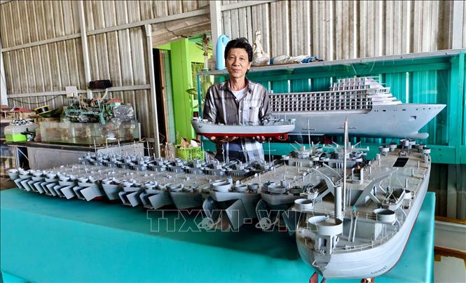 Anh Đệ bên nhiều mô hình mô hình tàu chiến, du thuyền đang chờ bàn giao cho khách hàng. Ảnh: Thanh Sang-TTXVN