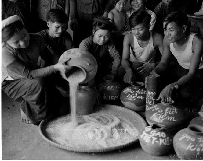 Đoàn viên, thanh niên xã Tam Sơn, huyện Yên Dũng, Bắc Giang đổ gạo từ các hũ tiết kiệm, đưa vào quỹ tín dụng để hỗ trợ các đoàn viên khi cần thiết (28/6/1960). Ảnh: Đức Như – TTXVN