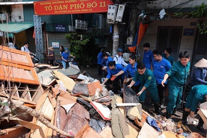 Lực lượng thanh niên tình nguyện tại phường Chương Dương (quận Hoàn Kiếm, Hà Nội) hỗ trợ thu gọn, vận chuyển đồ đạc bị hư hỏng của người dân do ảnh hưởng của cơn bão số 3, ngày 14/9/2024. Ảnh: Hoàng Hiếu – TTXVN