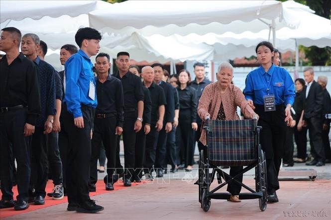 Lực lượng thanh niên tình nguyện hỗ trợ người cao tuổi đến viếng Tổng Bí thư Nguyễn Phú Trọng tại nhà văn hóa thôn Lại Đà, xã Đông Hội, huyện Đông Anh, Hà Nội (7/2024). Ảnh: TTXVN