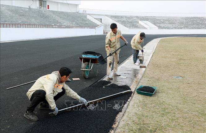 Đường pitch đang được thảm những mét cuối cùng. Ảnh: Quốc Khánh - TTXVN