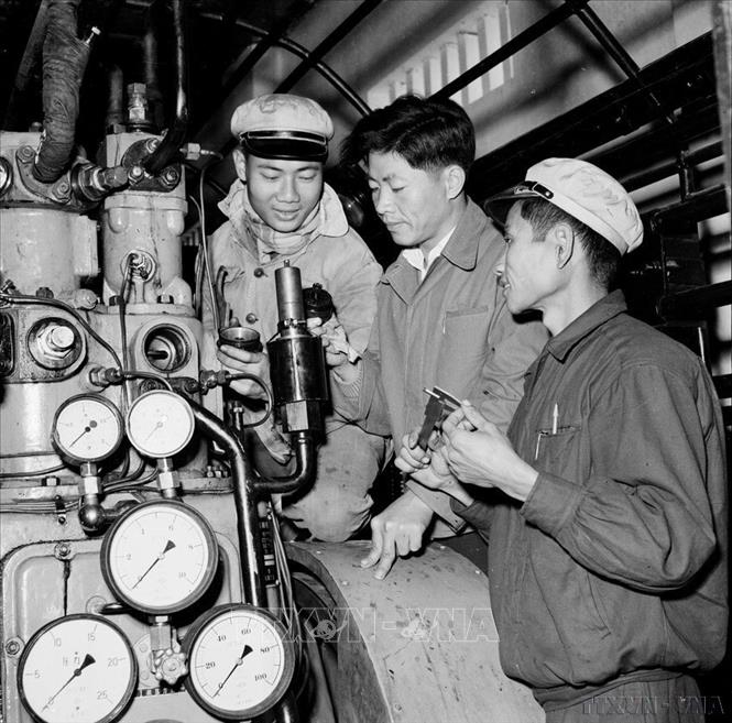 Chuyên gia Trung Quốc (giữa) hướng dẫn công nhân Việt Nam tháo lắp, tu sửa van thoát hơi nước tự động trong nhà máy ép K65 (9/1960). Ảnh: Trần Phác - TTXVN