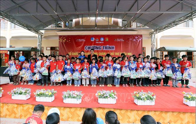 Tặng quà cho các em học sinh Trường Tiểu học Chiềng Ngàm, xã Chiềng Ngàm, huyện Thuận Châu, tỉnh Sơn La. Ảnh: Quang Quyết - TTXVN