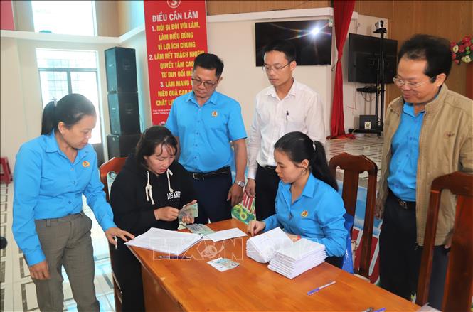 Đại diện Liên đoàn Lao động thành phố Bảo Lộc và các cơ quan chức năng chi trả lương cho người lao động bị công ty nợ hơn 1 năm qua. Ảnh: TTXVN phát