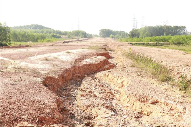 Dừng thi công dài ngày nên nền đường Dự án đường Hùng Vương nối dài (Quảng Trị) bị xói lở. Ảnh: Nguyên Lý - TTXVN 