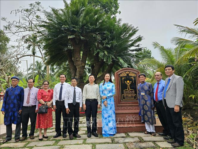 Các đại biểu chụp ảnh lưu niệm dưới tán cây Thiên tuế 10 ngọn 