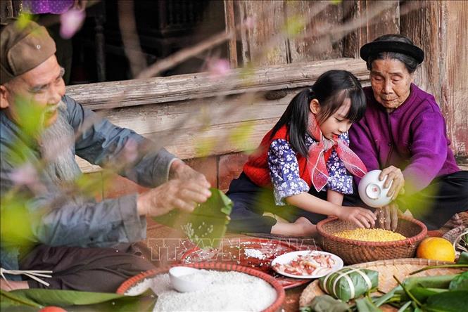 Các thế hệ quây quần gói bánh chưng mỗi dịp Tết đến Xuân về là nét đẹp trong văn hóa người Việt. Ảnh: Khánh Hòa - TTXVN