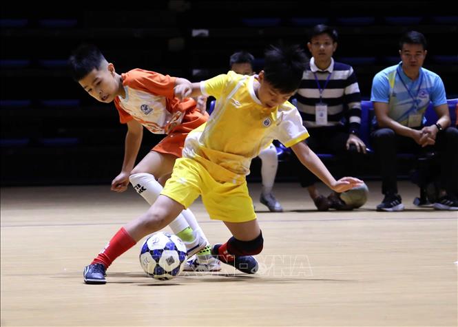 Pha tranh bóng quyết liệt giữa cầu thủ đội bóng Cẩm Lệ (áo cam) và cầu thủ đội Hải Châu (áo vàng) trong trận khai mạc. Ảnh: Trần Lê Lâm – TTXVN 