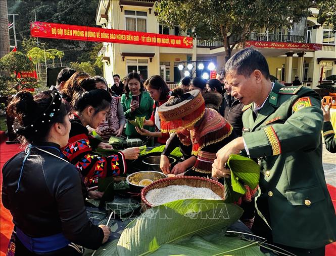 Dân bản và bộ đội biên phòng gói bánh chưng Tết. Ảnh: Đức Thọ - TTXVN