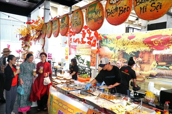 Phu nhân Đỗ Thị Hương Lan (giữa) tham quan gian hàng bán ẩm thực ba miền. Ảnh: Hằng Linh-PV TTXVN tại Kuala Lumpur.
