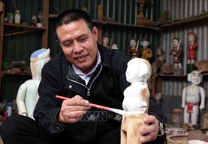 Nghệ nhân Nguyễn Văn Phi đã dành hơn một thập kỷ để chế tác và bảo tồn nghệ thuật múa rối nước của làng Đào Thục và là người duy nhất trong làng làm công việc này. Ảnh: Trần Việt - TTXVN