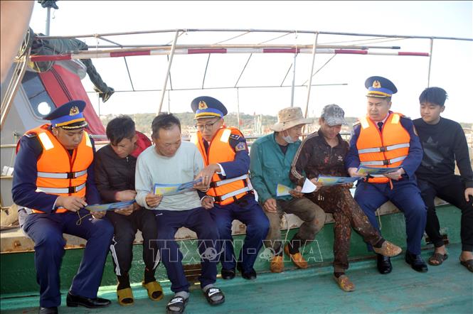 Tuyên truyền IUU cho bà con ngư dân đang neo đậu tàu tại âu cảng Bạch Long Vĩ. Ảnh: TTXVN phát