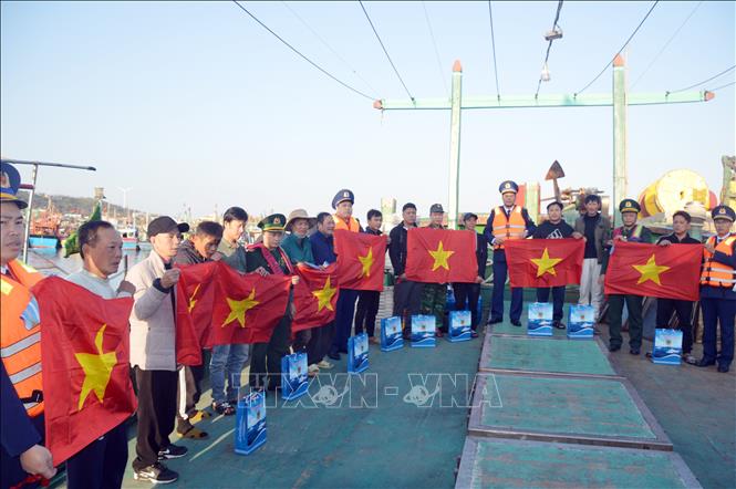Tặng quà Tết, cờ Tổ quốc cho bà con ngư dân tại âu cảng Bạch Long Vĩ. Ảnh: TTXVN phát
